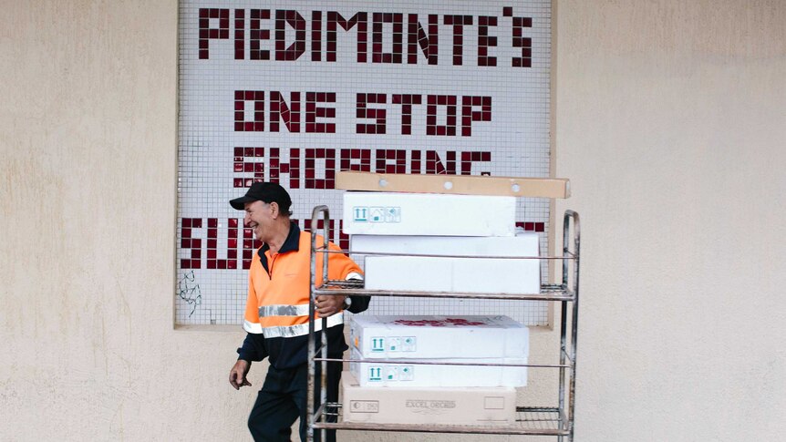 A man pulls a trolley full of fresh stock into the store.