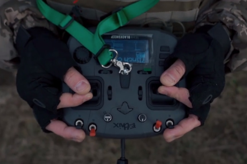 A soldier holding a racing drone controller. 