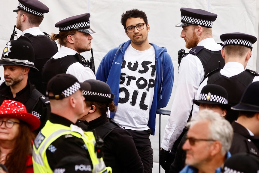 Police officers detain a member of "Just Stop Oil" movement during a protest ahead of King Charles's coronation.
