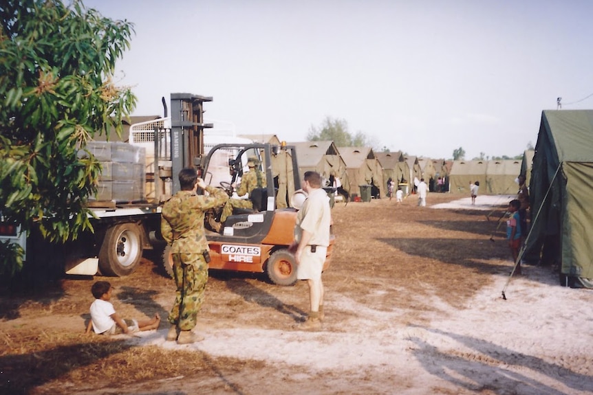 Old photo of tent city with military around it.