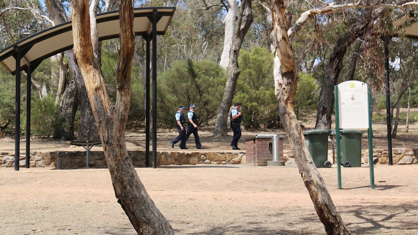 Police walk near the base of Mount Ainslie in Canberra's north.