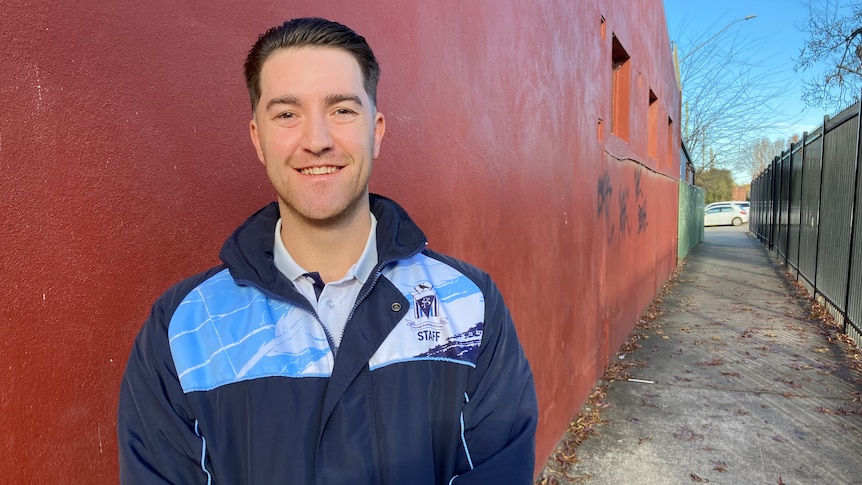Josh O'Callaghan stands in an alleyway wearing a Wagga Public staff jacket