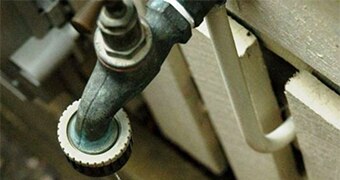 A close up photo of a dripping garden tap