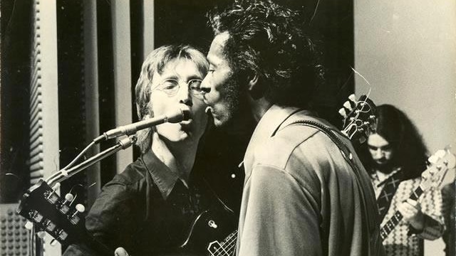 John Lennon and Chuck Berry sing into the same microphone