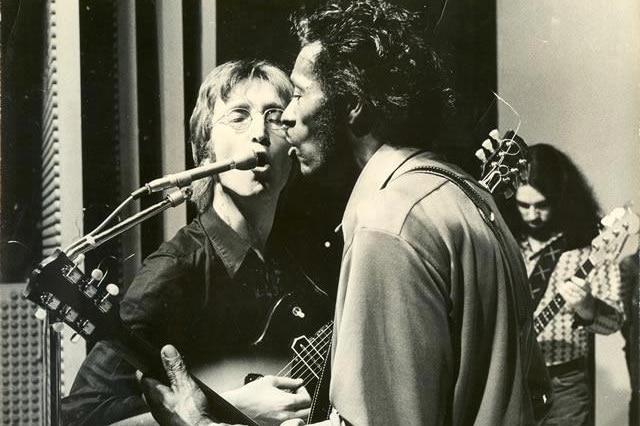John Lennon and Chuck Berry sing into the same microphone