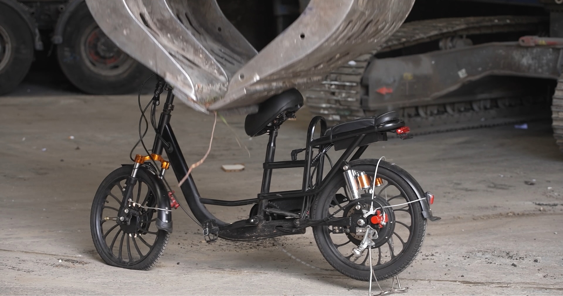 a mechanical claw crushing an e-bike