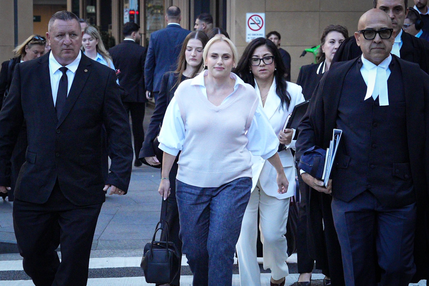 गुलाबी और सफेद टॉप में गोरी महिला मुस्कुरा रही है