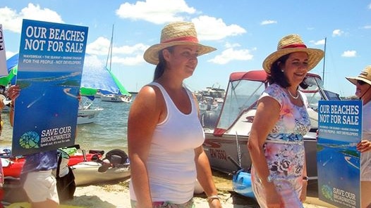 Queensland Premier Annastacia Palaszczuk (on right) steps ashore onto Wave Break Island