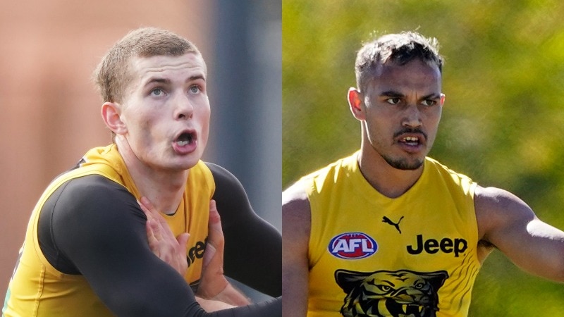 Callum Coleman-Jones looks up grappling with a man off camera and Sydney Stack (right) kicks an AFL ball