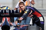 Sebastian Vettel helps push his car back to the pits
