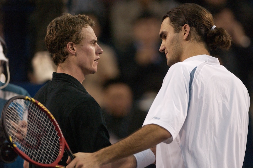 Two men shake hands after a tennis match.