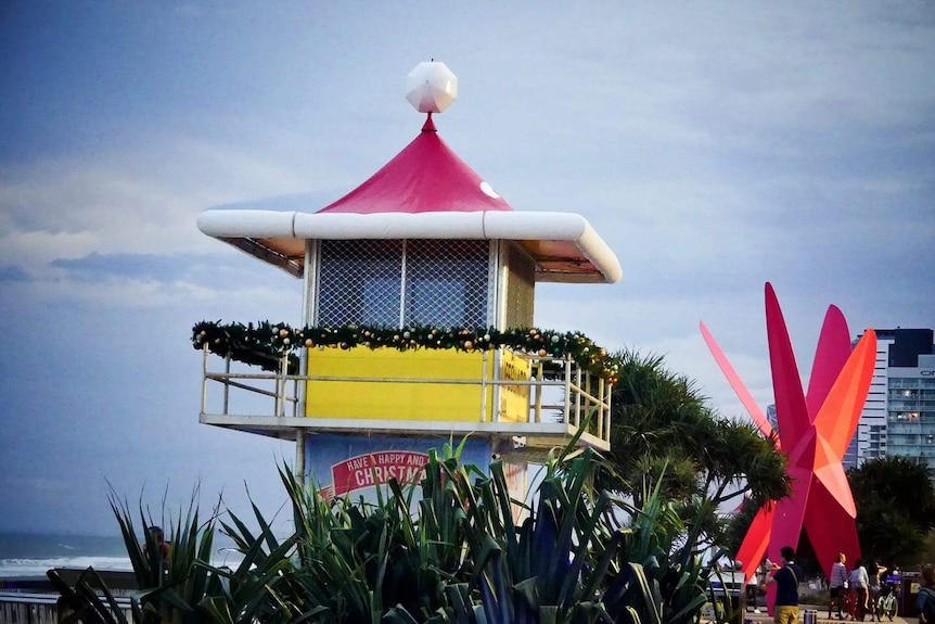 A lifeguard tower adorned with its roof modified to look like a Christmas hat.