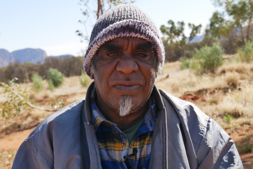 Traditional Owner Douglas Multa sits in an open space in the West MacDonnell Ranges
