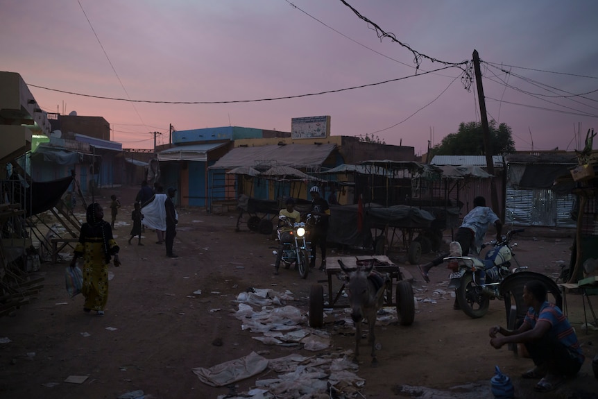 Residents walk around the central market area in Selibaby, Mauritania at dusk.