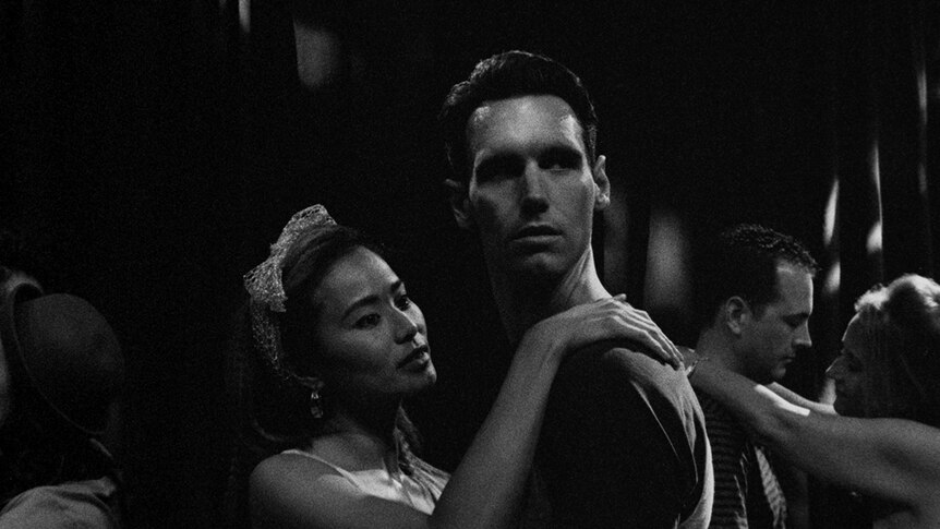 A black and white still of Cory Michael Smith and Jamie Chung dancing together in the 2018 film 1985.