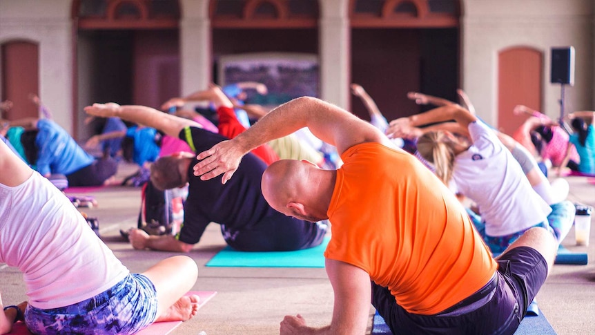 People striking a pose in an indoor yoga class