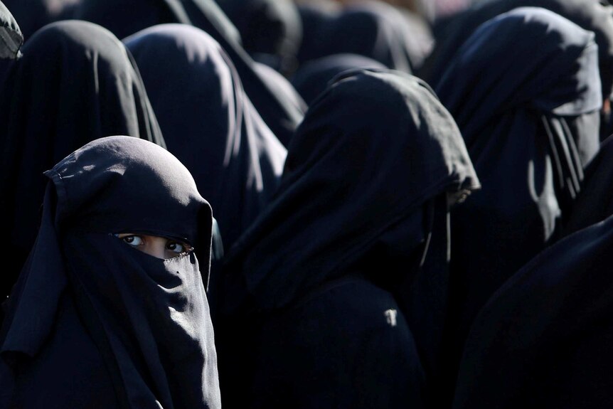 A group of women in niqabs, one with only her eyes visible.