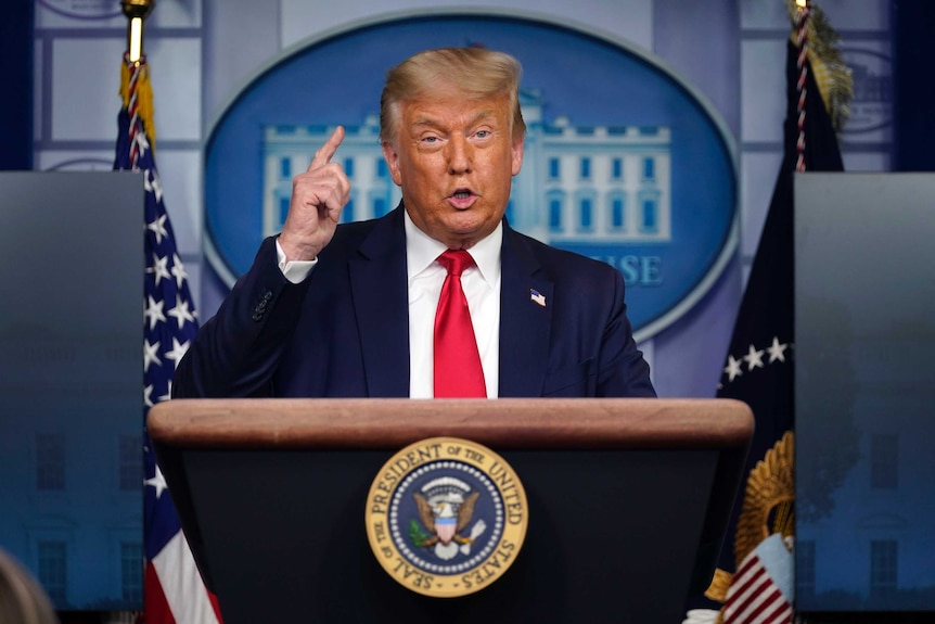 President Donald Trump speaks from a podium during a news conference at the White House