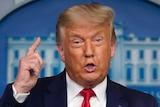 President Donald Trump speaks from a podium during a news conference at the White House