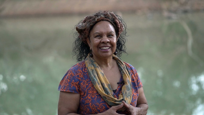 An Australian Indigenous woman is smiling at the camera.