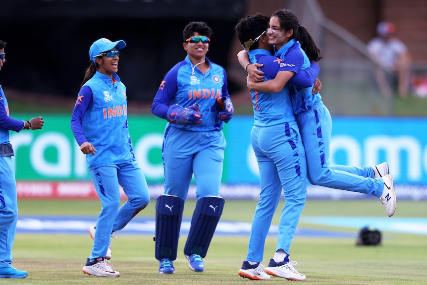 An Indian bowler smiles as her teammate lifts her off the ground in celebration after a T20I wicket. 