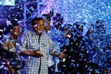 A seventy year old man in a blue and white checked shirt was showered with confetti.