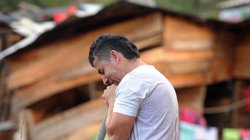 A man cries as he searches for relatives among rubble following the landslide in La Gabriela.