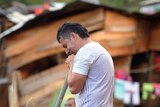 A man cries as he searches for relatives among rubble following the landslide in La Gabriela.