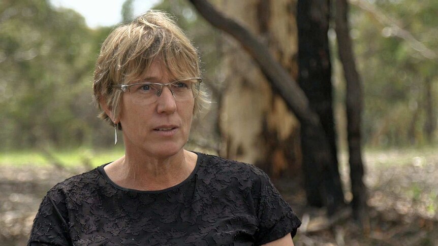 Clare Murphy wears glasses and a black top.