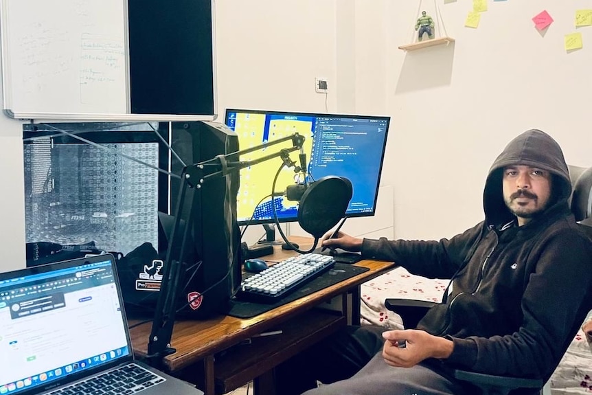 A man wearing a hoodie in a multi-media studio.  