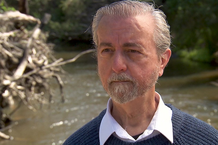 Photo of a man in front of a body of water.