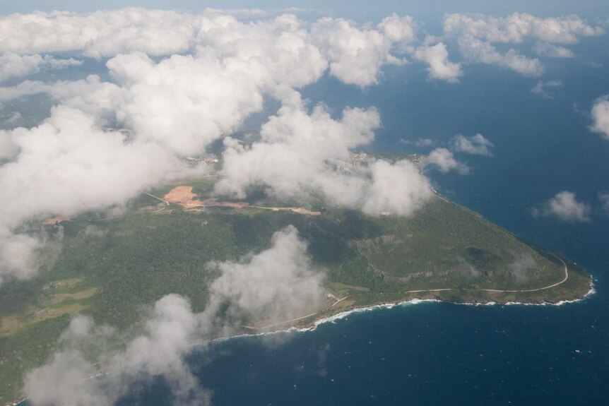 An aerial view of Christmas Island with the Phosphate Hill mine site visible below clouds.