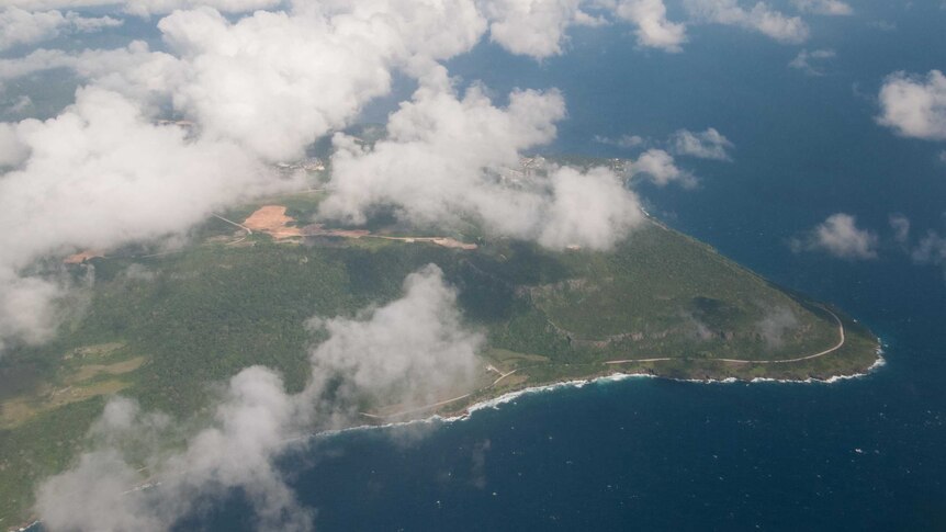 An aerial view of Christmas Island with the Phosphate Hill mine site visible below clouds.