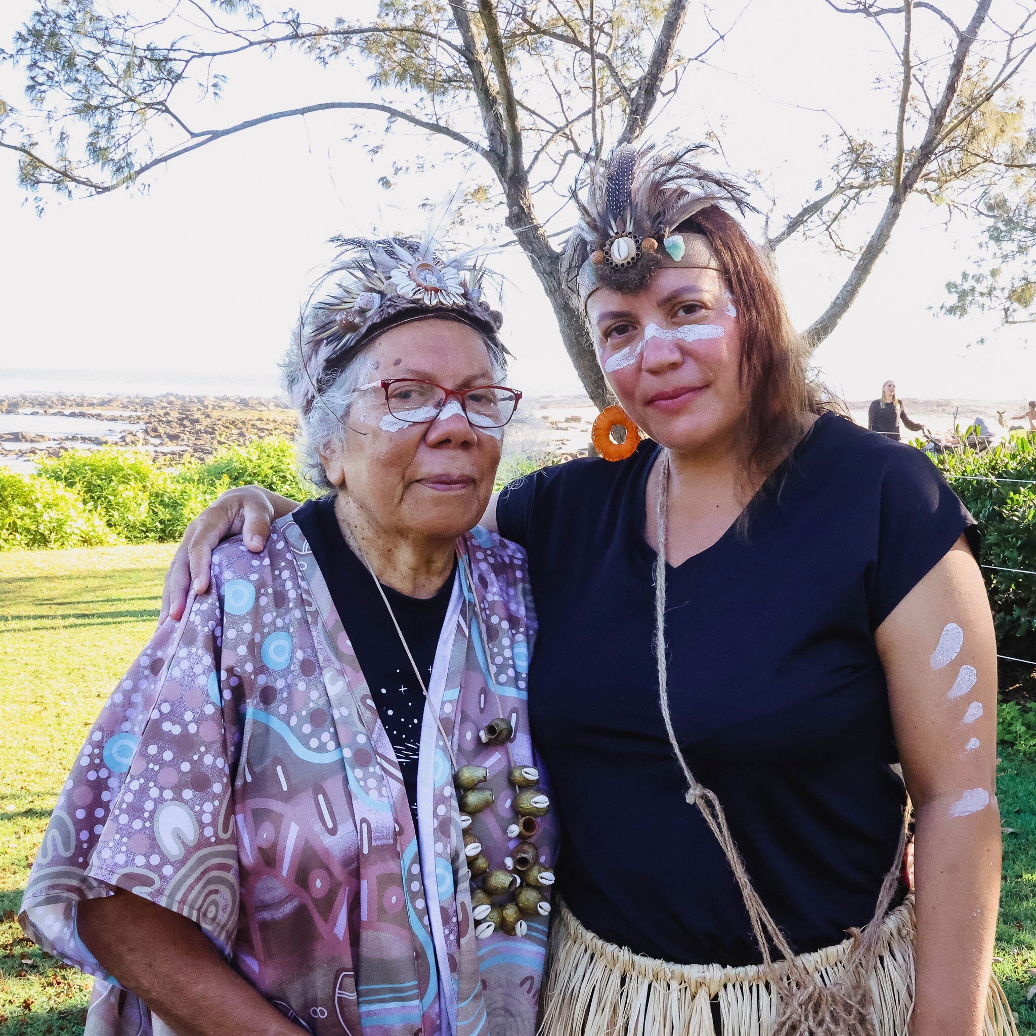 Frances Parker (right) has an arm around Aunty Lenore Parker's shoulder (left) in outdoor nature setting