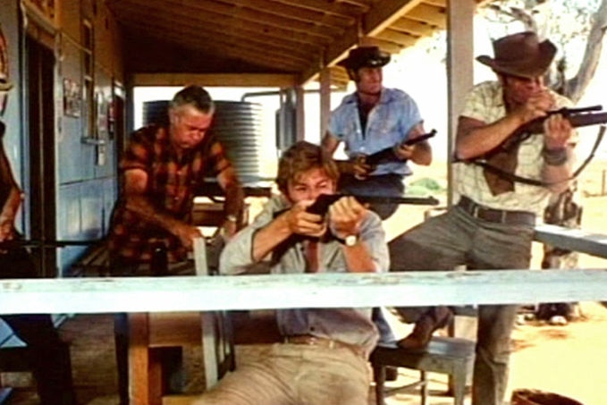 Men holding guns sit on the verandah of an outback home