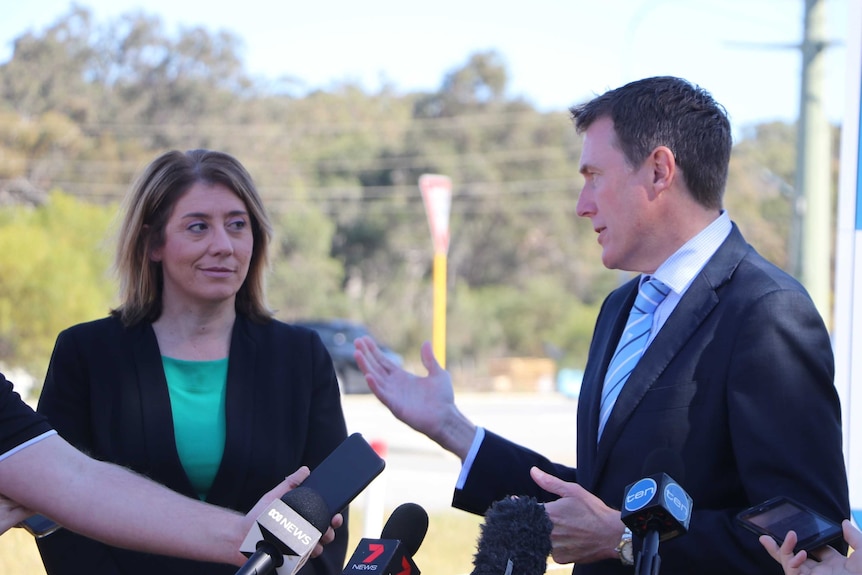 Christian Porter explaining something to Rita Saffioti, both standing outside.