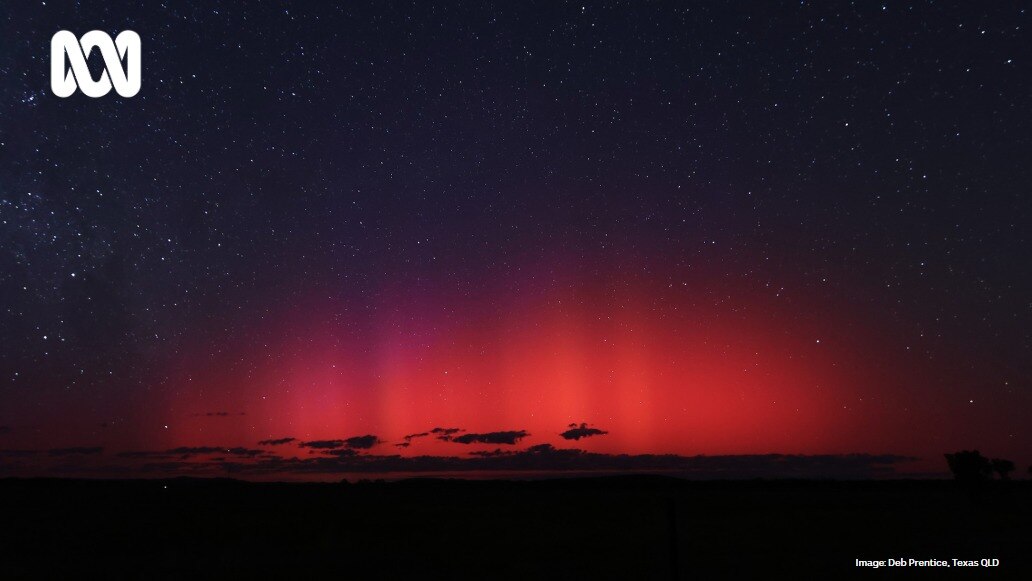 A red and pink aurora in the night sky