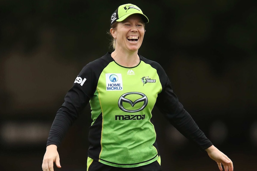 ASydney Thunder WBBL player laughs as she fields against the Melbourne Stars.