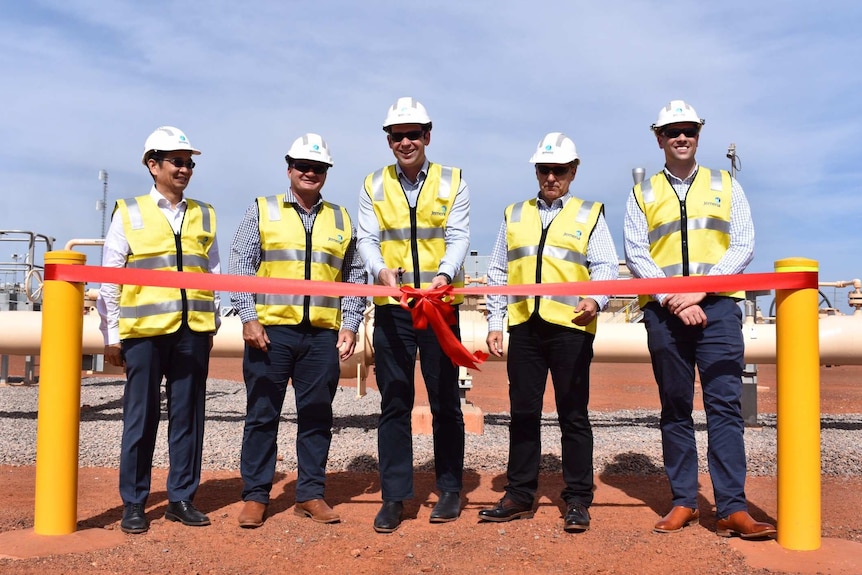 Politicians cut a ribbon to open a Central Australian pipeline.