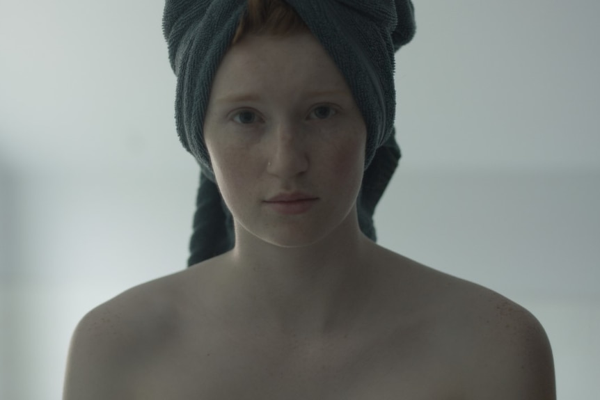 A young girl with a towel on her head. 