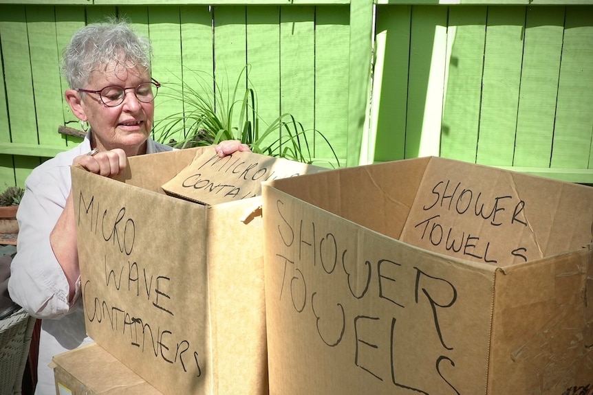A person propping up two large cardboard moving boxes