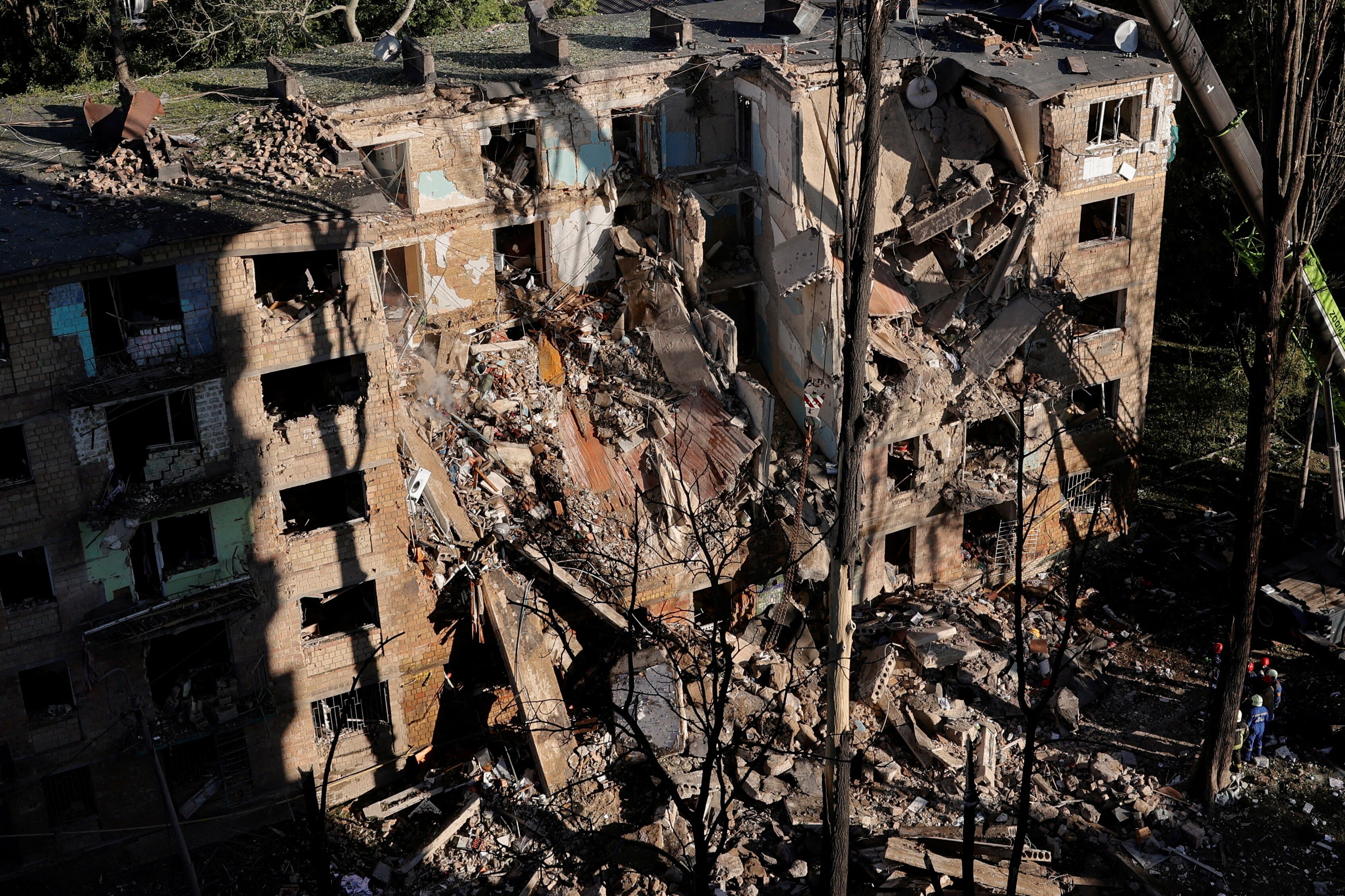 An apartment block in Kyiv with a large hole blasted into the side of it, partially collapsing multiple floors.
