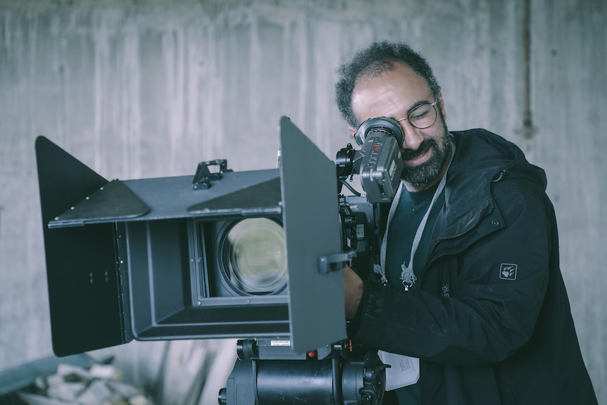 an Iranian man behind a camera 