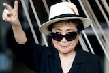 Yoko Ono giving the peace sign