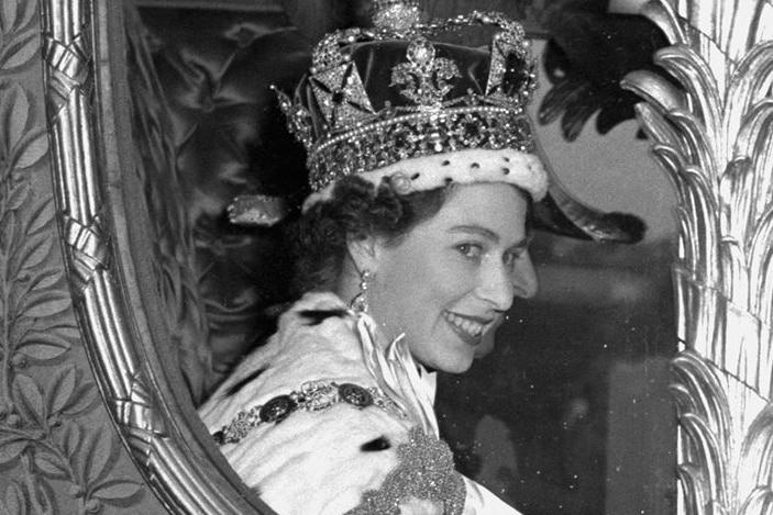 Queen Elizabeth II smiles through the window of a coach after her coronation in 1953.