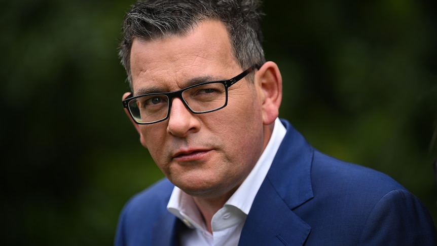 A close-up photograph of Daniel Andrews, wearing glasses and a navy suit jacket.
