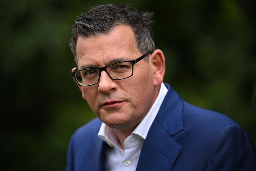 A close-up photograph of Daniel Andrews, wearing glasses and a navy suit jacket.