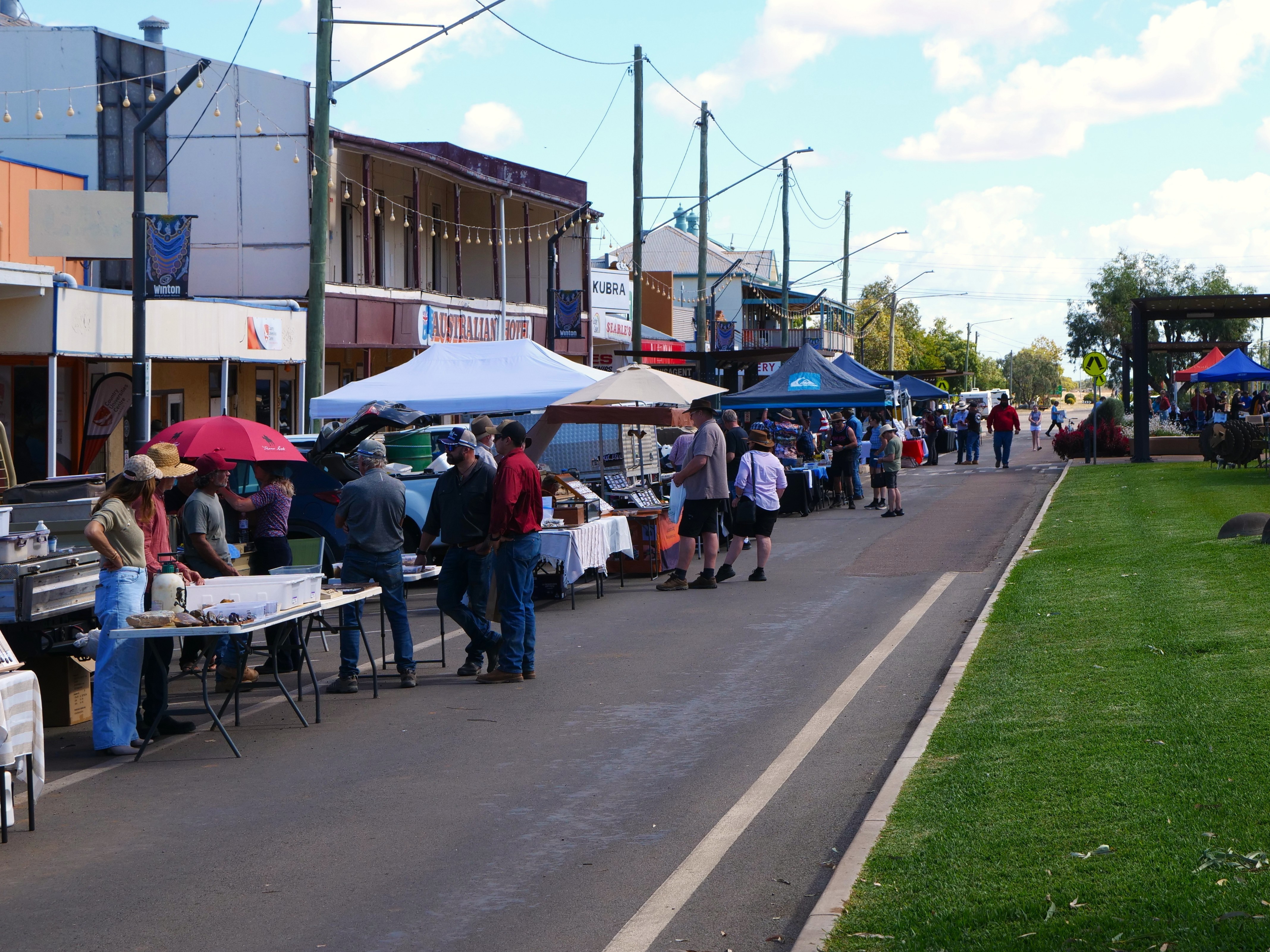 A marquees and folding tables out the front of shops on a main drag.