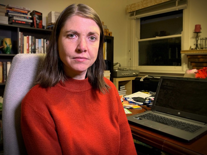 Sonia Marcon sits in her study at home, with books and a laptop in the background.