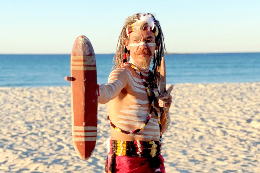 First Nations man in traditional dress at the beach